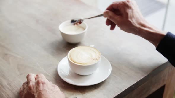 Close-up of a man who is drinking cappuccino in a cafe