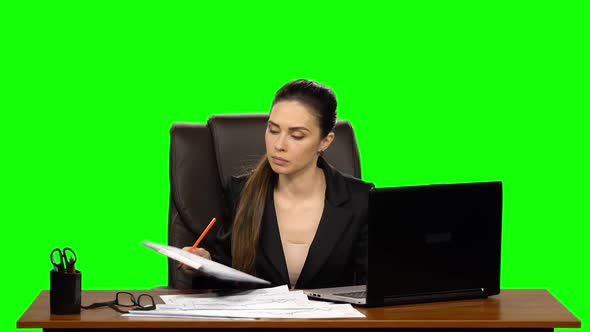 Female Manager Works on a Laptop, Think and Takes Notes. Green Screen Background