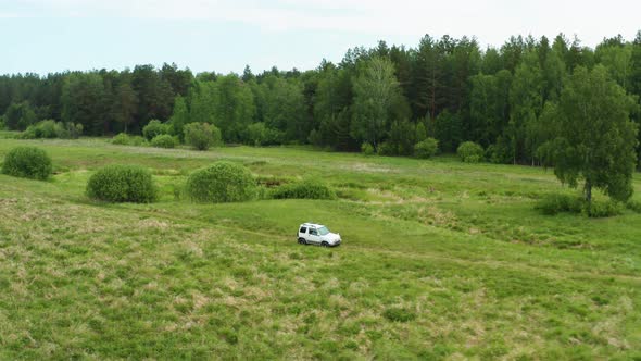 Aerial View of a Car Driving in Nature Near the River