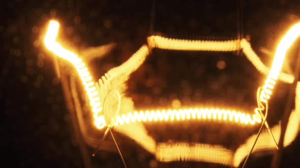 Tungsten Filament in a Glass Lamp Closeup in Slow Motion on Black Background