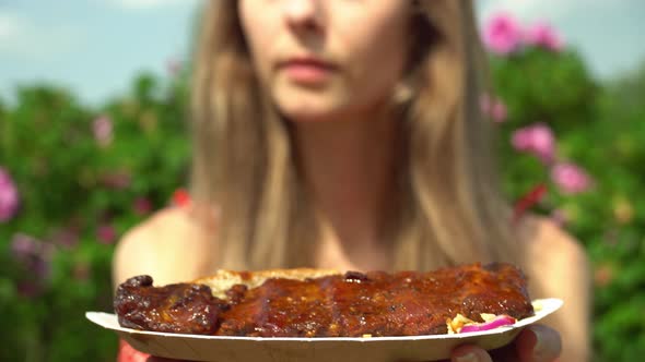 Roasted and Tasty pork ribs Barbecue Grilled. Girl smells the aroma of grilled meat on a walk