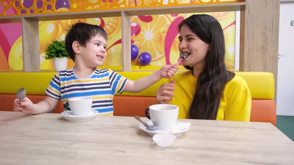 Mom and Son Eat in the Playroom Drink Cocoa and Eat Chocolates Feed Each Other