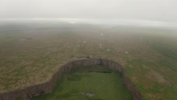 Aerial View Of Asbyrgi Glacial Canyon With Light Fog In The Horizon In Iceland.