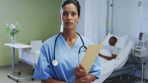 Front view of African american female doctor looking at camera in the ward at hospital