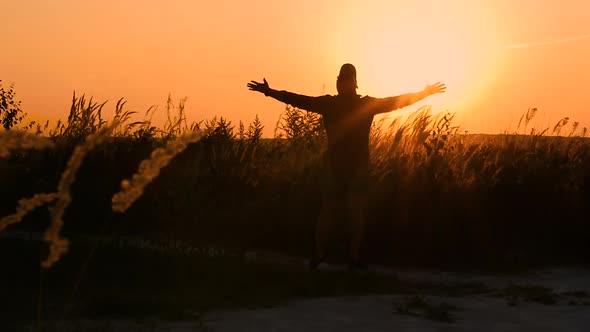 Happy Man Enjoying The Sunset, The Man Spread His Arms To The Sides Looking At The Sun