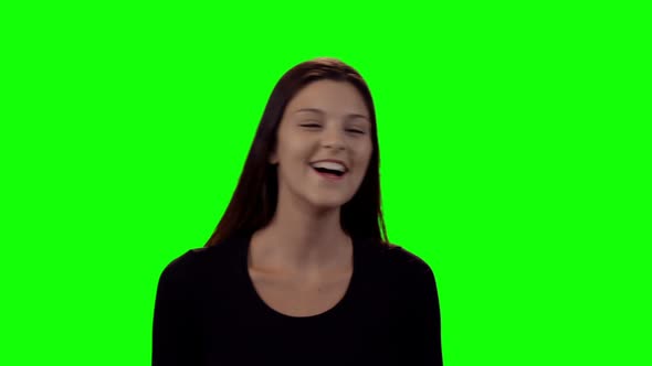 Smiling beautiful woman standing against green screen