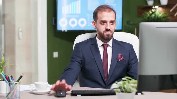 Smiling Sales Person in Business Suit Working on Computer