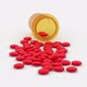 Red Round Pills Scattered on the Table From a Yellow Jar - VideoHive Item for Sale