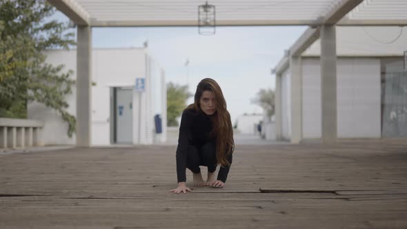 Young Woman on Wooden Bridge Looks Into Camera and Moves Like a Cat