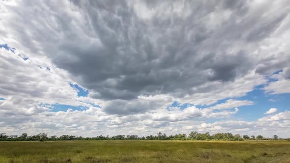 Cumulus clouds form and advance on flat Okavango time lapse landscape alt