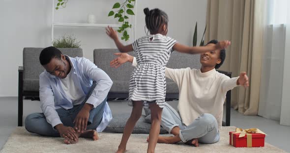 Three African American People Parents About Daughter Together in Living Room Mom Gives Little