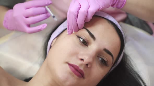 A woman on the procedure of injections in a cosmetology clinic