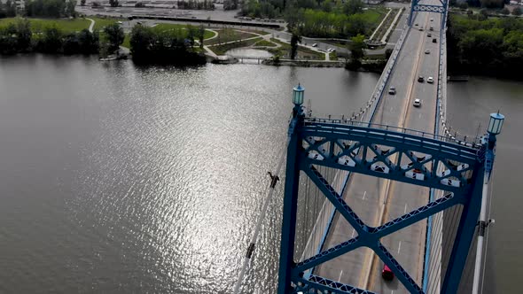 Drone flying over circling bridge with cars driving and canoe and the river