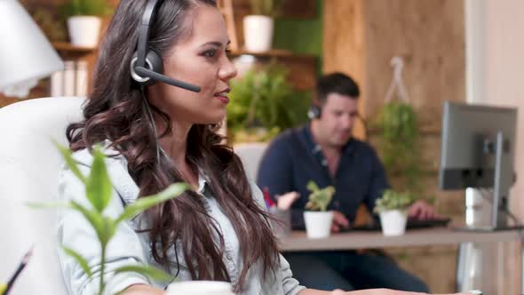 Close Up Portrait of Female Sales Representative Talking with a Client Through a Headset