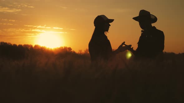 Team Farmers Stand in Wheat Field Holding Tablet and Use Technology To Predict the Future