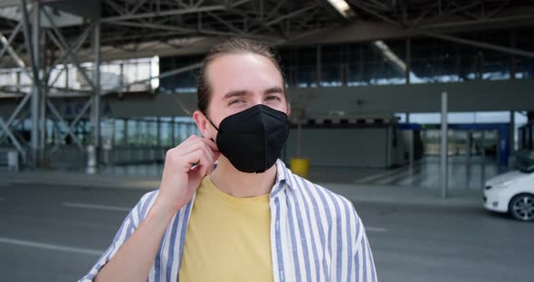 Young man with face mask taking selfie at the airport.