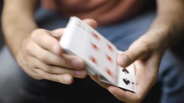 Male hands shuffle playing cards and browse through deck, close-up