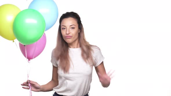 Portrait of Joyful Woman with Long Hair Dancing and Having Fun While Holding Colorful Ballons on Her