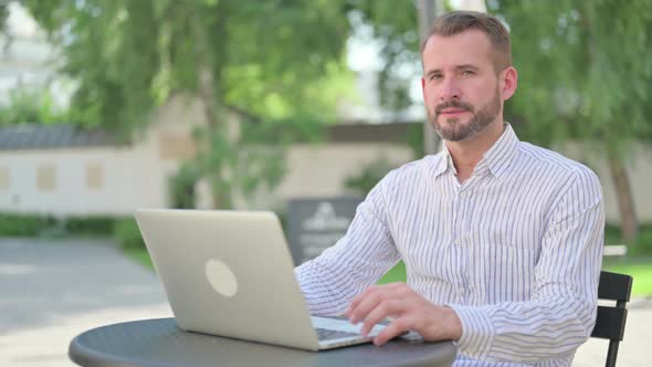 No Gesture with Finger By Middle Aged Man in Outdoor Cafe