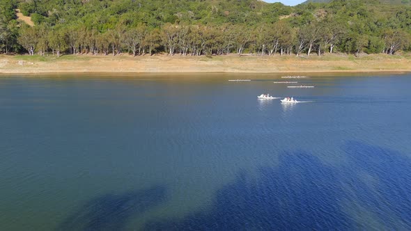 Race Of Rowing Teams On The Lake Surface At Lexington Reservoir In California On A Sunny Day. drone