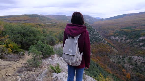 Hipster Woman with Backpack Walking at the Autumn Mountains Nature