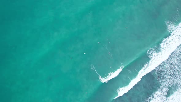 Top down of waves break on tropical sea Surfers with surfing boards Aerial drone view 4-k