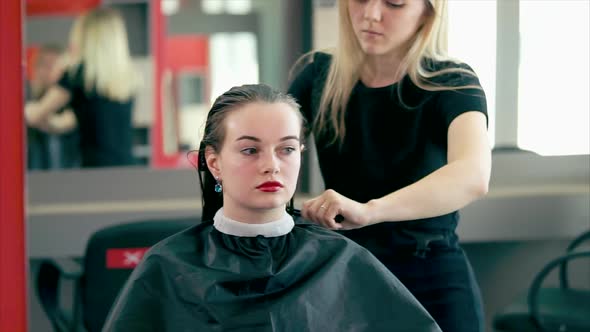 A Hair Stylist is Combing His Wet Hair in Order to Dry His Hair with a Hairdryer