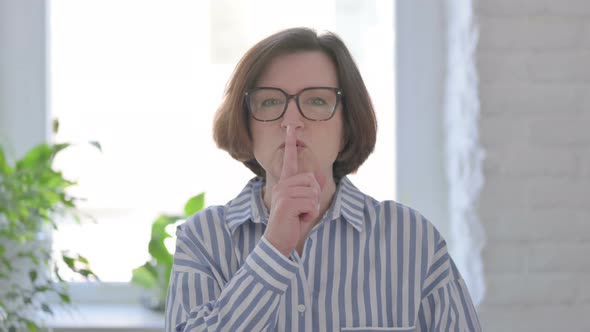 Senior Woman Putting Fingers on Lips Quiet Sign