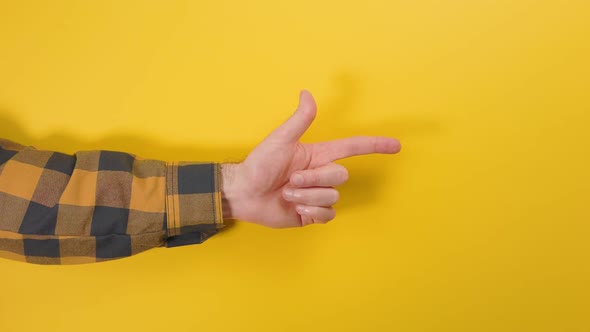 A man's hand in a shirt shows the direction of the index finger of the hand to the right side.