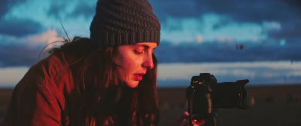 Person adjusts camera while shooting sunset