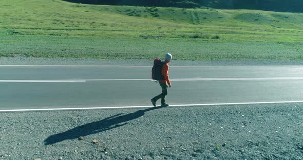 Flight Over Hitchhiker Tourist Walking on Asphalt Road