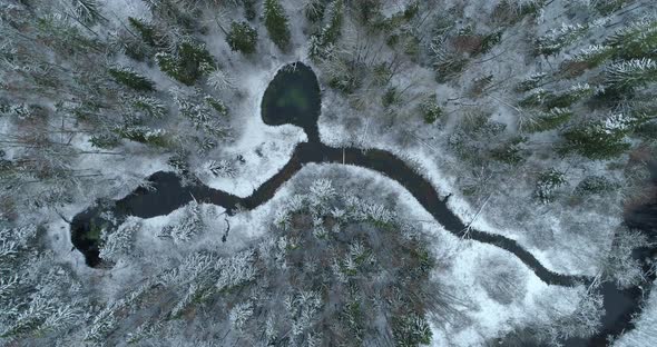 Water Flowing To River From Springs in Snowy Winter Forest Aerial View