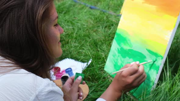 Young Attractive Woman Artist Paints on Nature