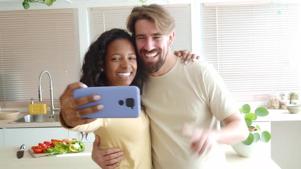 Happy Multiethnic Couple Taking a Selfie in the Kitchen of Their New Apartment