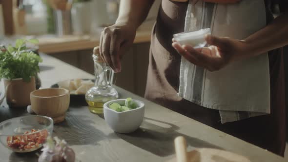 Woman Adding Salt to Food Ingredients
