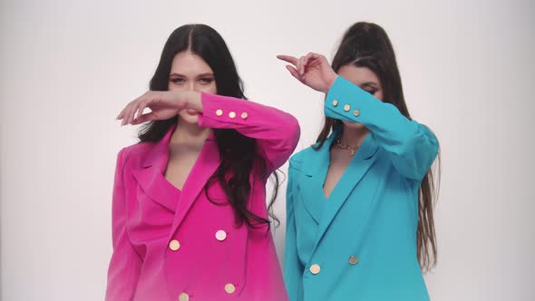 Two Young Women Models in Pink and Blue Blazers Posing on White Background