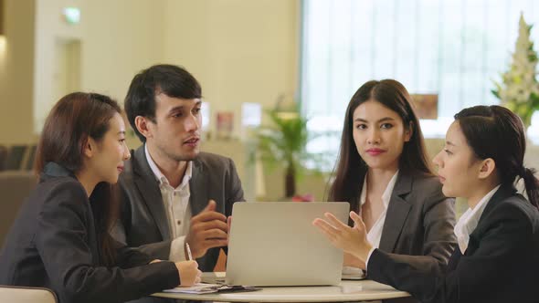 group of Businessmen and woman talking at meeting in modern design office with laptop and paper docu