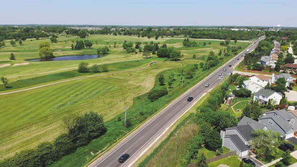 Aerial Over Driving Between Small Towns. Traffic on US Roads.