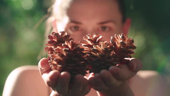 Portrait Of A Pretty Happy Woman Holding Pine Cones In Hands With Bright Sunlight