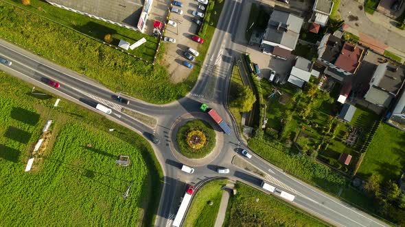 Vehicles Driving At Roundabout On A Sunny Day In Lubawa, Poland. - aerial top-down shot