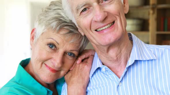 Portrait of smiling senior couple posing together in living room