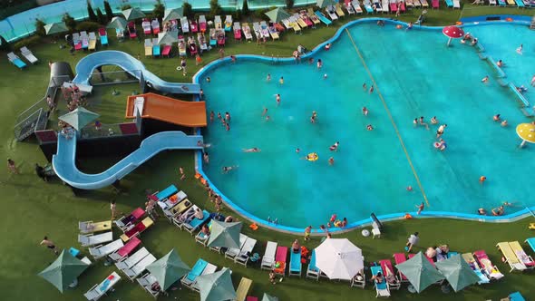 People swim and have fun in the large pool at the water park.