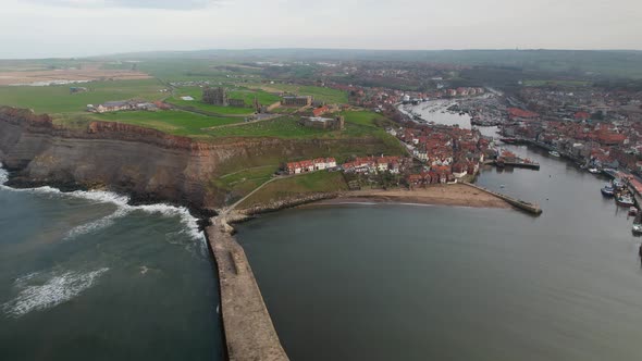 Waterfront City At The Harbour Overlooking Ruins Of Whitby Abbey In North Yorkshire, England. Aerial