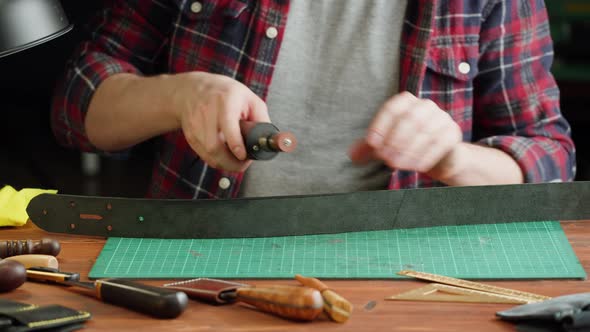 Man Tailor Polishing Artificial Leather Closeup