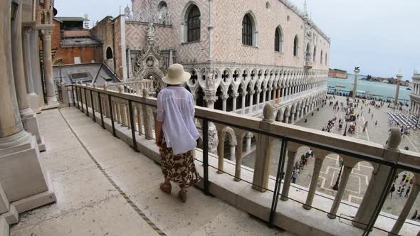 Woman looking at San Marco Square from the balcony of basilica, Venice, Italy