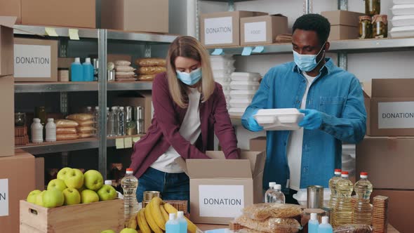 Diverse Volunteers in Masks and Gloves Working at Food Bank