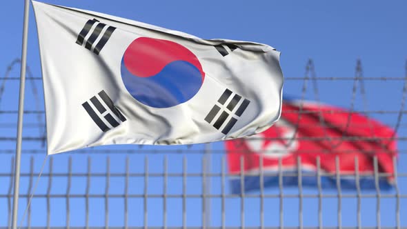 Flags of South Korea and North Korea Separated By Barbed Wire