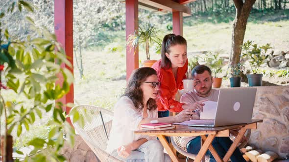 Team of Three Young Entrepreneurs Discussing a Startup Project