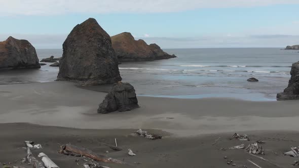 Aerial of stunning landscape of an undeveloped wild Oregon beach.  Rock islands, driftwood, waves, d