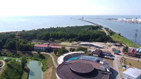 Lithuania sea gates and reveal shot of dolphinarium in Smiltyne, aerial descend view